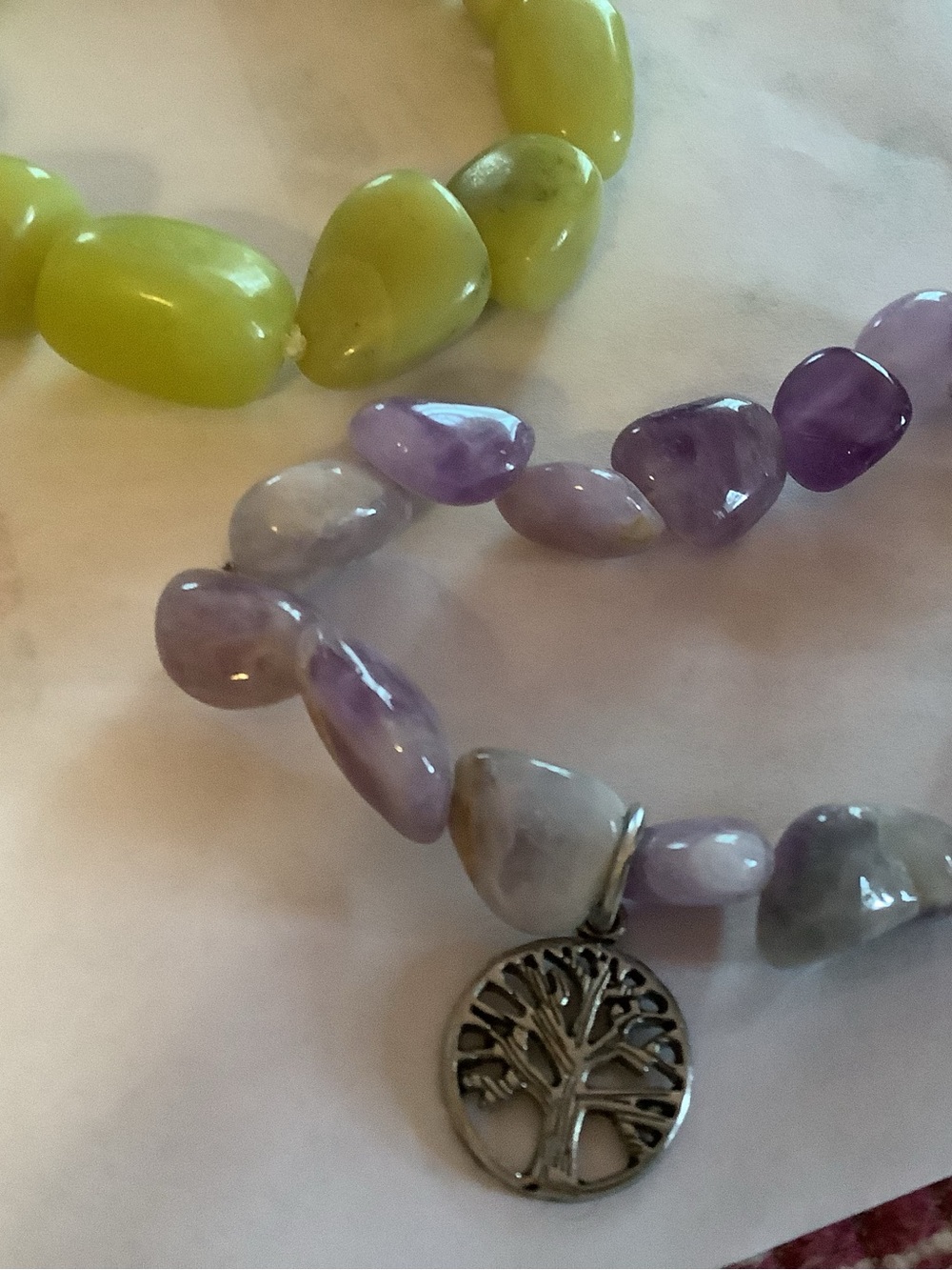 Two stretchy bracelets..one with Tree of Life charm in silver tone